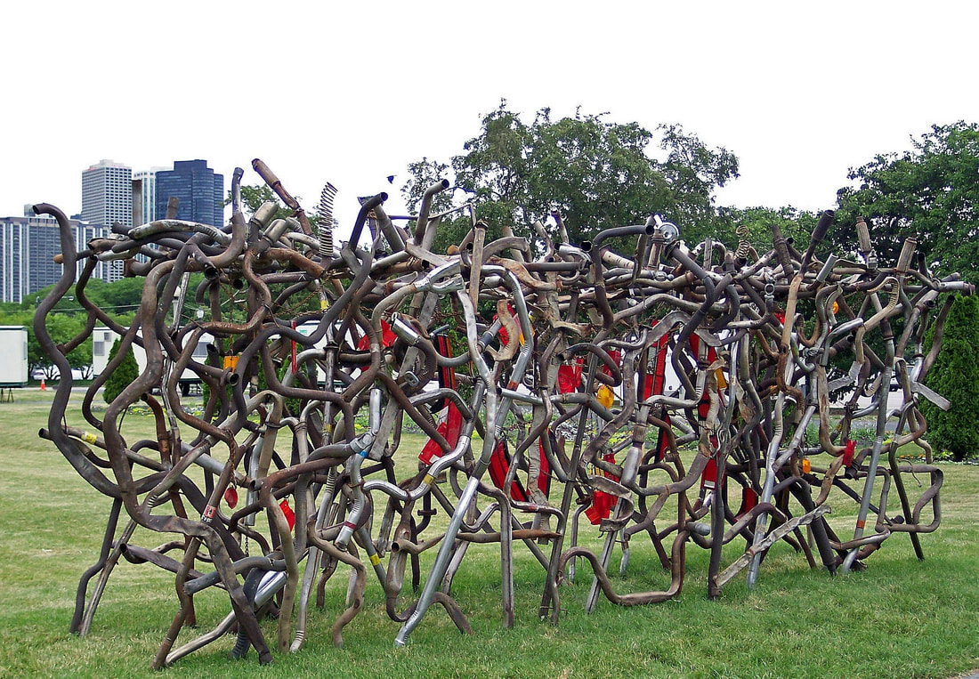 Abstract sculpture created by Lucy Slivinski made from salvaged car tail pipes and reflectors, located in Grant Park, Chicago.