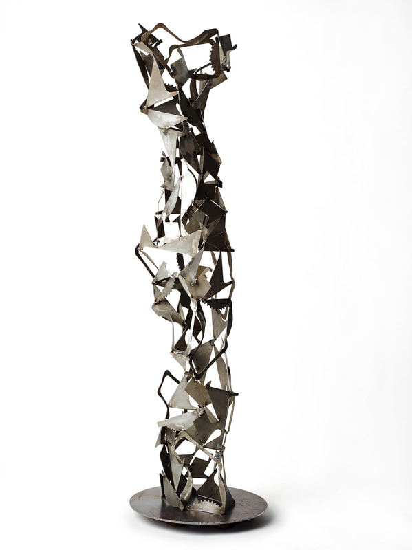 Tall abstract metal sculpture created from salvaged metal into a column form. Created by Lucy Slivinski.