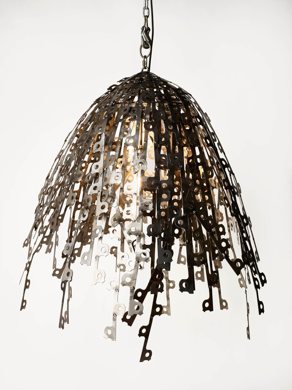 Lucy Slivinski Lighting “Flare” Welded, found objects, recycled metal punch outs, lighting  41’’H x 38’’W x 35’’L